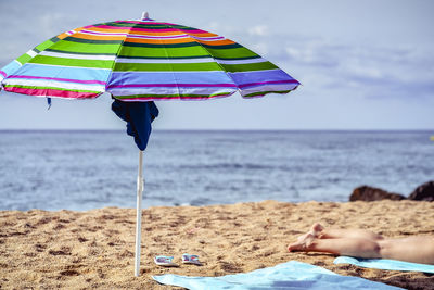 Umbrella on beach against sky