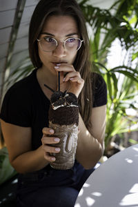 Close-up of woman drinking cold coffee in cafe