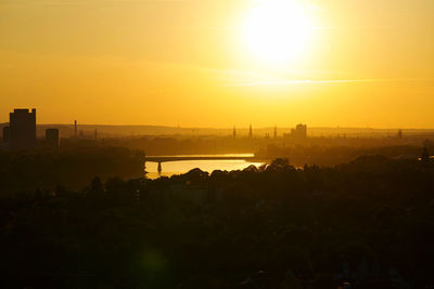 Silhouette buildings against sky during sunset