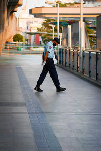 Full length side view of security guard on footpath