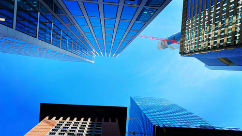 Low angle view of modern buildings against blue sky