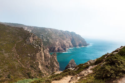 Scenic view of sea and mountains against clear sky