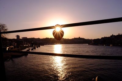 View of bridge over river in city at sunset