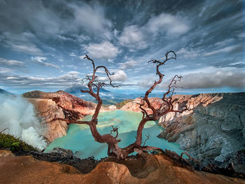 Scenic view of rocky shore against sky