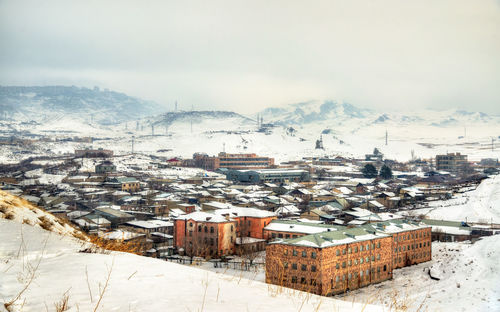 High angle view of snow covered houses against sky