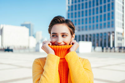 Portrait of young woman standing in city