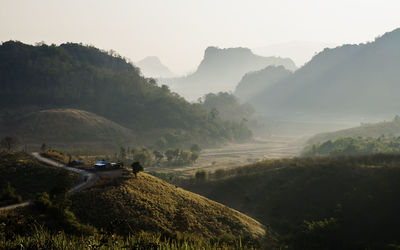 Scenic view of field and mountains against sky