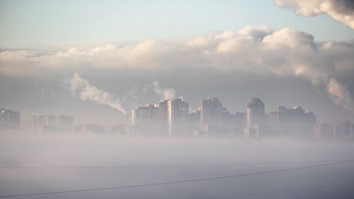 Smoke emitting from chimney of factory against sky