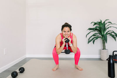 Portrait of young woman exercising in gym