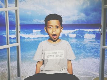 Portrait of boy on beach against sky