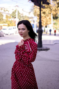 Portrait of young woman standing on road