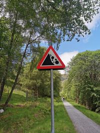 Information sign by road against trees