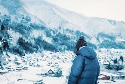 Rear view of person standing on snow covered mountain