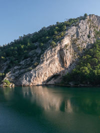 Scenic view of lake by mountain against sky