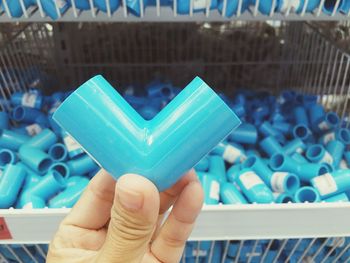 Close-up of hand holding blue plastic