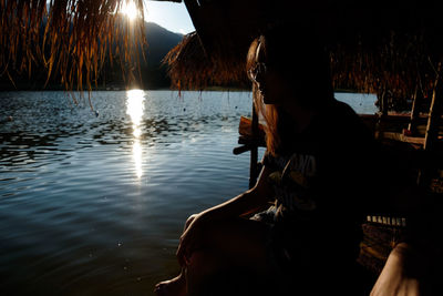Side view of man sitting on boat in lake