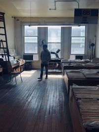 Rear view of man standing on table