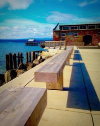 Pier on sea against cloudy sky