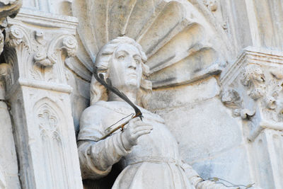 A statue of a marble writer on the cathedral - como, lombardy, italy.