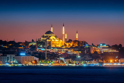 Illuminated buildings in city against sky