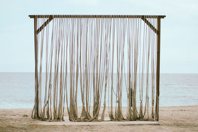 Wooden posts on beach against clear sky