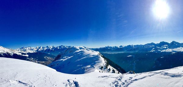 Scenic view of snow mountains against blue sky