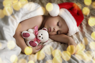 Cute sleeping young boy in santa claus hat. christmas light. winter holiday. toddler baby christmas.