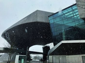 Low angle view of modern buildings in city during winter