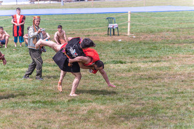 People playing with dog on field