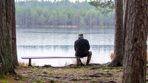 Rear view of man standing by lake