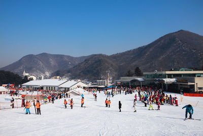 Group of people on mountain range against clear sky