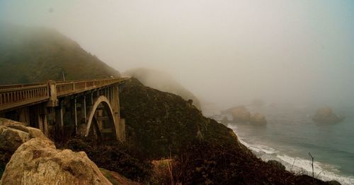 Arch bridge over mountains against sky