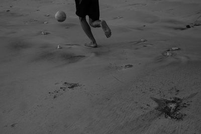 Low section of man walking on beach