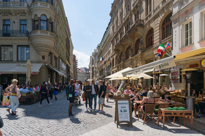 People on street amidst buildings in city