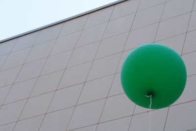 Low angle view of balloons against building