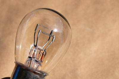 Close-up of illuminated light bulb against wall