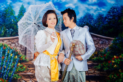 Young couple wearing traditional clothing on carpet