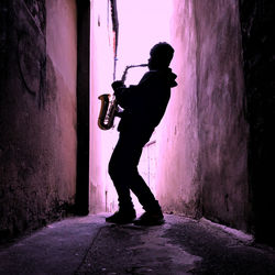 Full length of silhouette man standing against wall in building