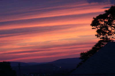 Scenic view of silhouette mountains against orange sky