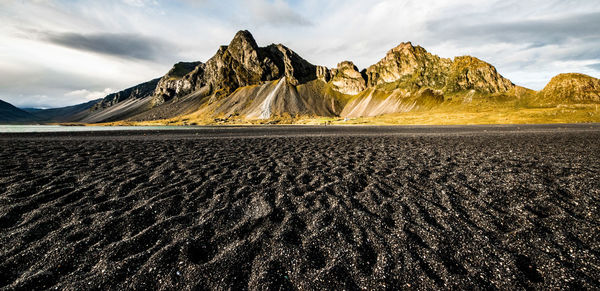 Scenic view of vestrahorn against sky and black beach
