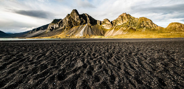 Scenic view of land and mountains against sky