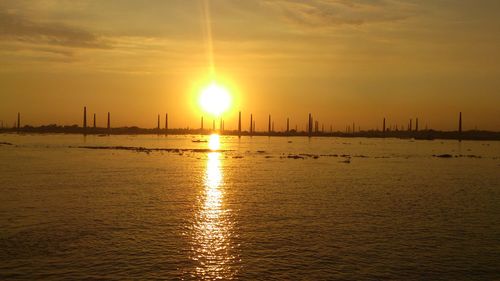 Sailboats in sea at sunset