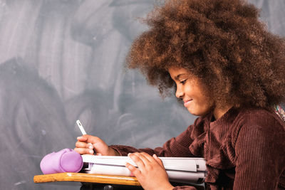 Woman looking at camera while sitting on book