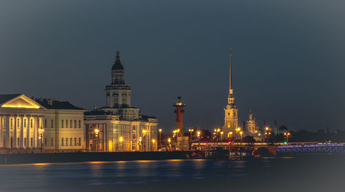 Illuminated buildings against sky at night