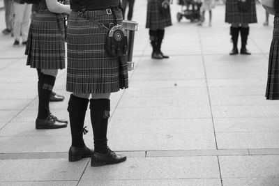 Low section of bagpipe standing on footpath