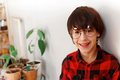 Portrait of smiling boy against wall at home