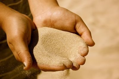 Close-up of hand holding sand 