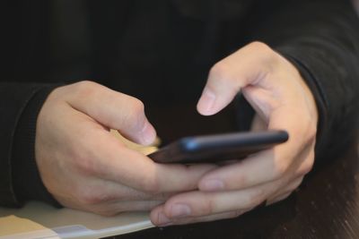 Midsection of man using mobile phone