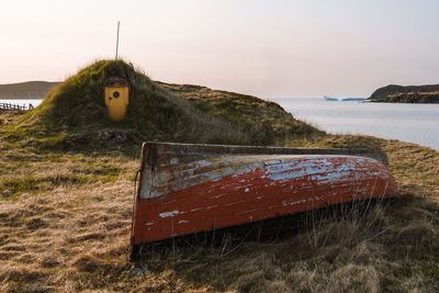 Abandoned fishing boat with icebergs in the background in spring, twillingate, newfoundland, canada