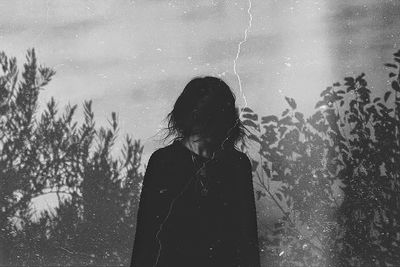 Low section of woman standing against trees